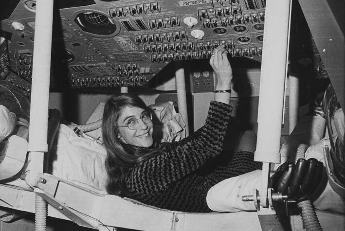 Per una foto promozionale scattata al MIT, Hamilton ha sorriso mentre azionava un interruttore in una riproduzione del modulo di comando dell'Apollo 12.